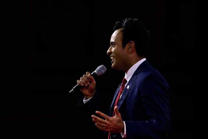 Man in a suit speaking into a microphone on stage