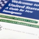 A guide for new immigrants alongside permanent resident cards and an American flag