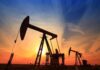 Silhouetted oil pumps against a colorful sunset sky