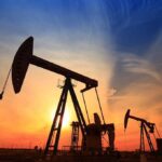 Gas Price Blame Game: FINGER POINTING BEGINS Silhouetted oil pumps against a colorful sunset sky