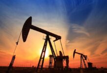 Silhouetted oil pumps against a colorful sunset sky
