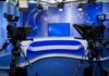 A television studio setup with cameras and a blue backdrop
