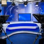 Top Correspondent Out—Backlash Erupts A television studio setup with cameras and a blue backdrop