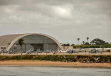 Airport Inferno Jolts Gulf Aircraft hangar with helicopters near the beach.