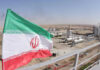 Dueling Claims Explode: Iran Rejects U.S. Nuclear Inspection Claim Iranian flag near an industrial gas refinery.