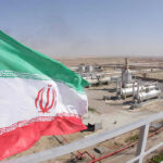 Dueling Claims Explode: Iran Rejects U.S. Nuclear Inspection Claim Iranian flag near an industrial gas refinery.