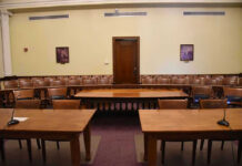 25-Year Sentence for SBF Upheld by Court Empty courtroom with wooden tables, chairs, and a door.