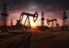 Oil rigs operating at sunset in a desert landscape.