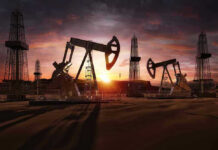 Oil rigs operating at sunset in a desert landscape.