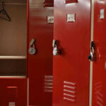 Federal Crackdown Hits Michigan Schools Red lockers with padlocks, one open with hanger.