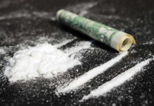 School-Zone Drug Ring EXPOSED Powder lines, rolled dollar bill on black surface.