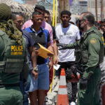 Terror Arrests ‘Almost Weekly’ Up North Border patrol agents inspecting group of individuals in line.