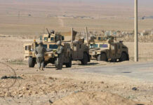US Strike Targets Alleged Venezuelan Gang Leader Soldiers beside military vehicles in a desert area.