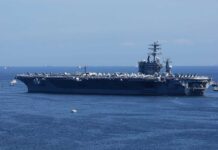 Trump Signals Iran De-Escalation as Markets Rise A large aircraft carrier sailing in the ocean