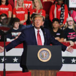 Trump Stuns Crowd With WWII and 9/11 Comparison Politician speaking at rally with supporters behind him.
