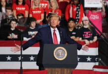 Trump Stuns Crowd With WWII and 9/11 Comparison Politician speaking at rally with supporters behind him.
