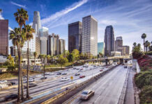 Downtown cityscape with skyscrapers and highway traffic.