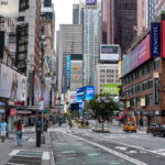 Record Heat Dome Puts Nearly Half of U.S. at Risk Times Square street scene with storefronts and advertisements.