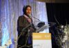 A Politician’s Views on Islam and Christianity Are Sparking a Religious Firestorm Woman in hijab speaking at a podium on a decorated stage