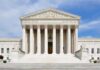 Supreme Court Shocker Reshapes Women’s Sports Front view of the Supreme Court building with large columns and steps under a blue sky