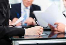 Crime, Deportation: The Debate Over What News Stories Should Say Close-up of a hand writing notes during a business meeting