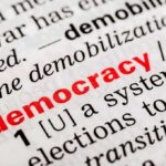 Close-up of a dictionary page defining the word democracy