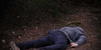 person lying face down on a forest path