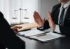 The AI Blame Game Just Went Global Businessman refusing an envelope at a desk