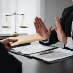 Businessman refusing an envelope at a desk
