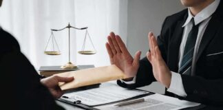 Businessman refusing an envelope at a desk
