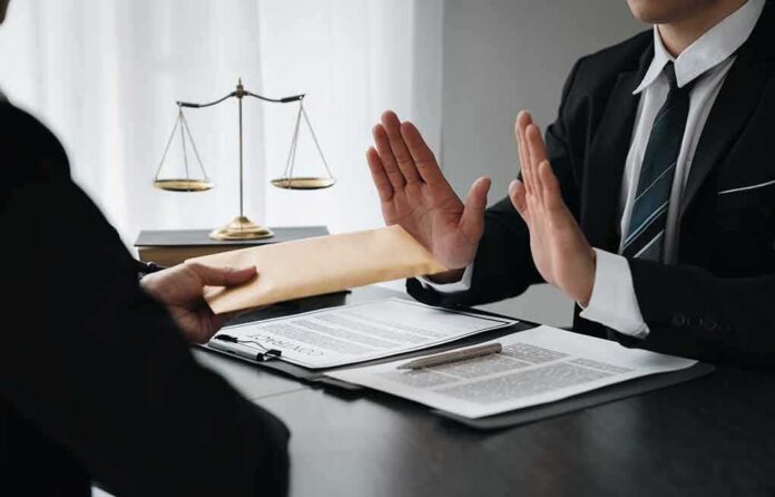 Businessman refusing an envelope at a desk
