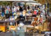 90% Gone in Days: Turkish Carpet Seller Reveals A bustling flea market with various antique items and furniture for sale