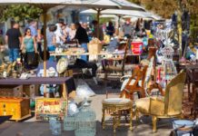 A bustling flea market with various antique items and furniture for sale