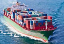 White House Hormuz Plan Hits a Legal Wall A large cargo ship loaded with colorful containers sailing on the ocean