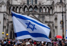Judge Says Protest Clash Could Be Racial Discrimination Israeli flag at a crowded outdoor event.