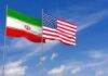 Iran and United States flags waving on flagpoles
