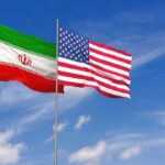 Iran and United States flags waving on flagpoles