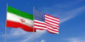 Iran and United States flags waving on flagpoles