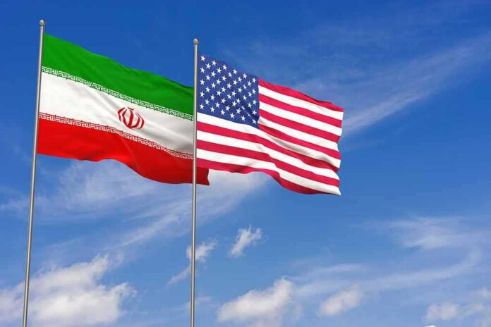 Iran and United States flags waving on flagpoles
