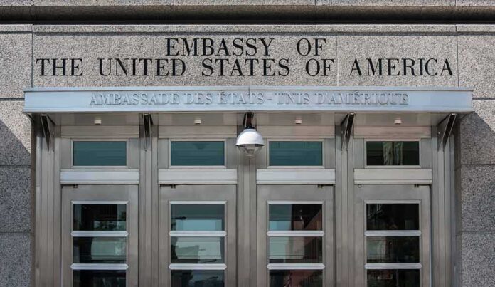 United States embassy entrance with metal doors and security camera