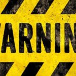 warning sign with yellow and black hazard stripes