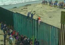 “Muslim Invasion” Claim Ignites Border Debate People climbing a tall beachside border fence