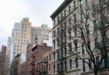 Manhattan Rents Hit Record Despite Freeze Street view of urban apartment buildings with fire escapes