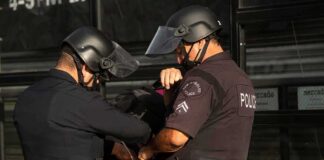 Police officers handcuff a person during an arrest