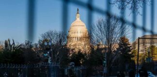 U.S. Capitol behind security fencing and guards on a street