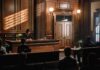 Lawmakers Probe Climate Training for U.S. Judges Judge presiding in a wood-paneled courtroom