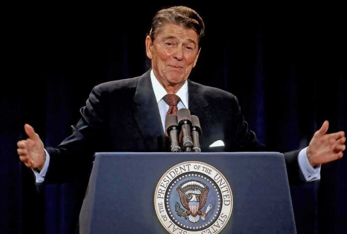 shutterstock_2318035165 man at presidential podium gesturing with arms open