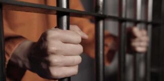 hands gripping prison bars