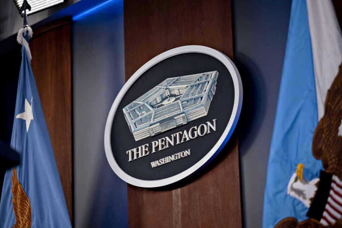 2265798341-3 The Pentagon emblem between two flags.