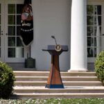 New Orders Shake Citizenship At Birth Podium with presidential seal in a garden colonnade